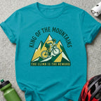 Turquoise t-shirt with mountain cyclist graphic and text "King of the Mountains".
