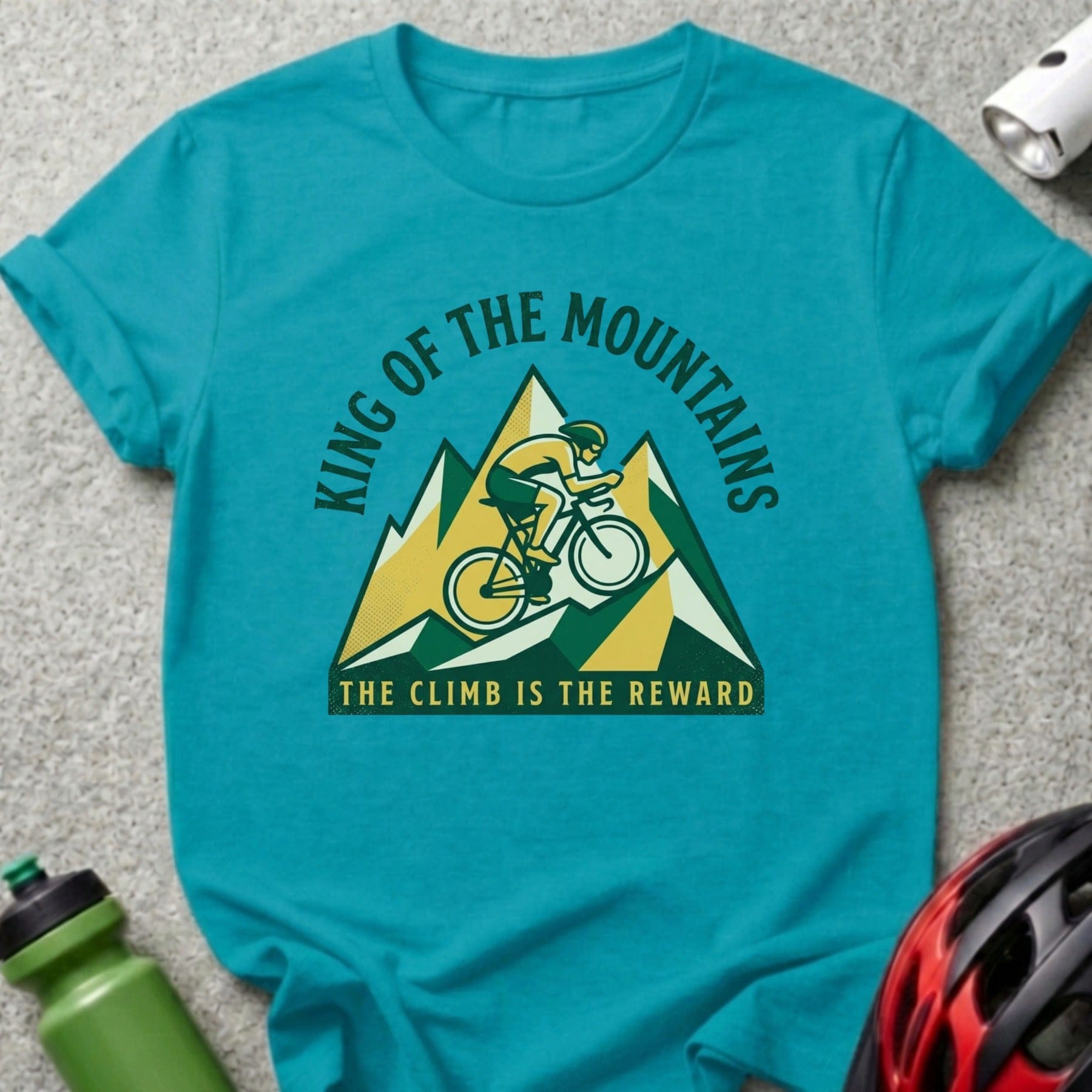 Turquoise t-shirt with mountain cyclist graphic and text "King of the Mountains".