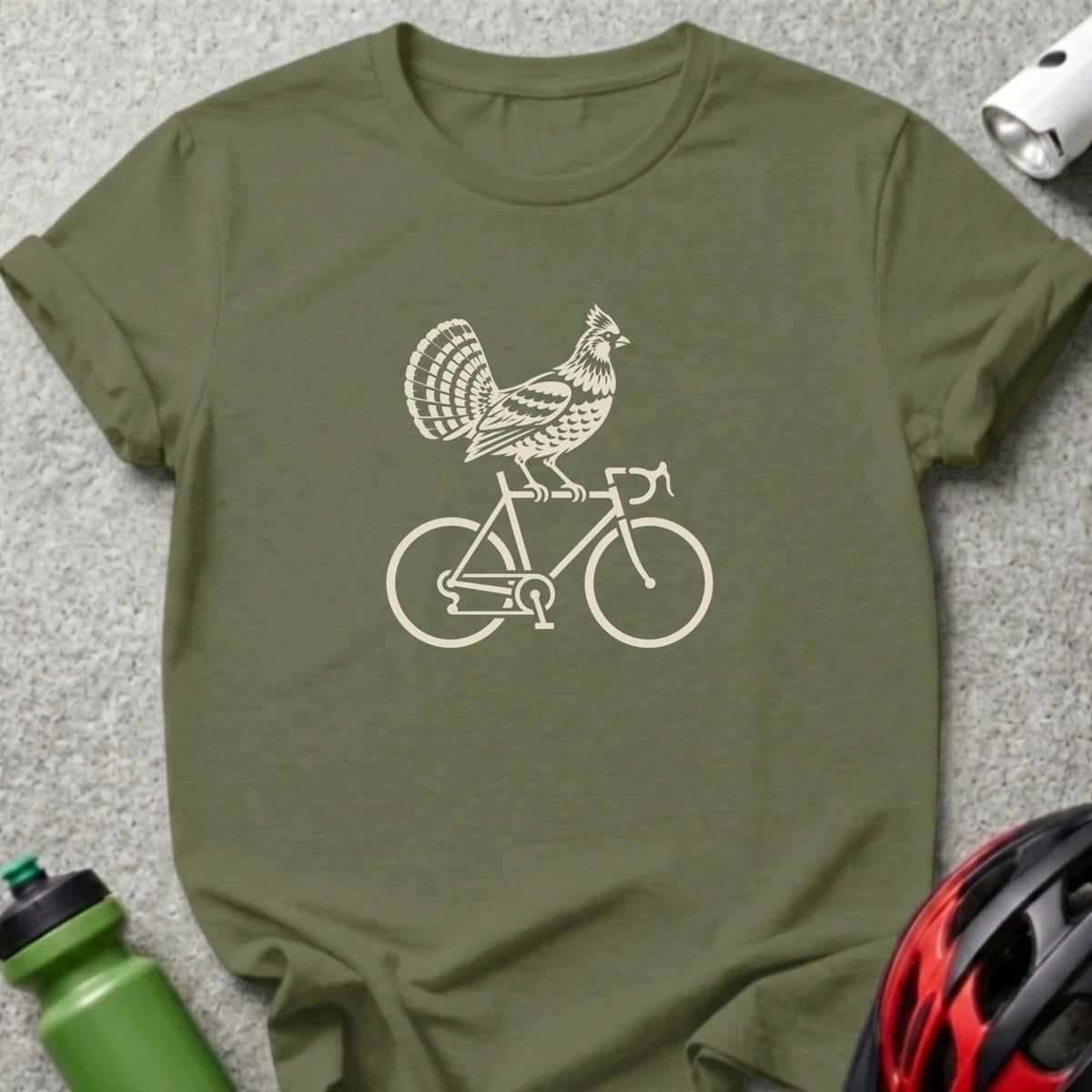 An olive green crewneck t-shirt featuring a cream-colored graphic of a turkey riding a bicycle.