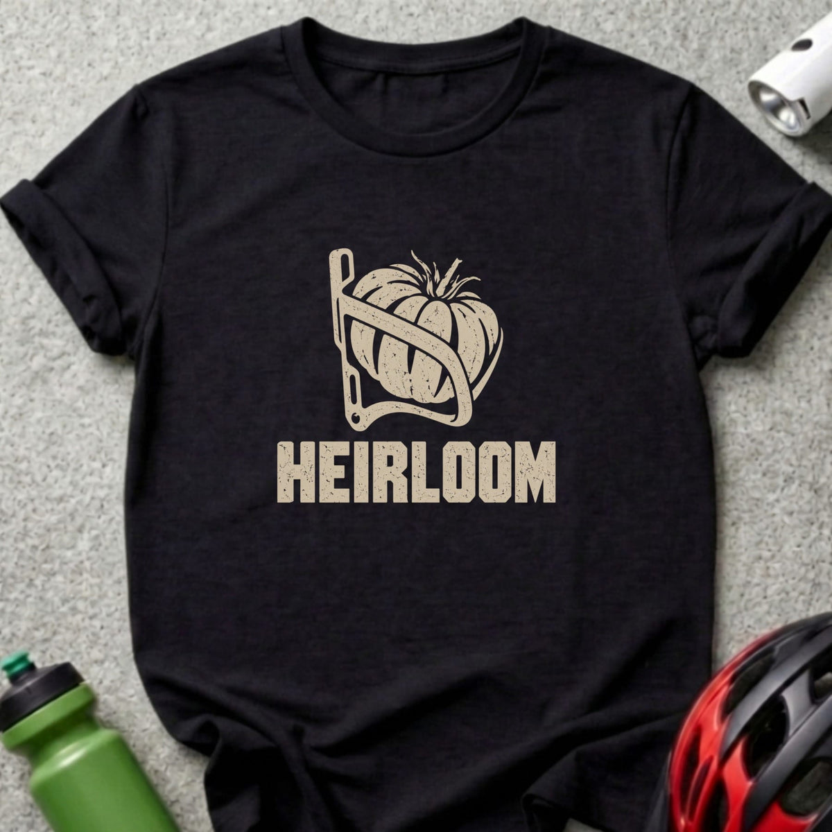 A black t-shirt featuring a graphic of a tomato in a bicycle bottle cage above the word HEIRLOOM.