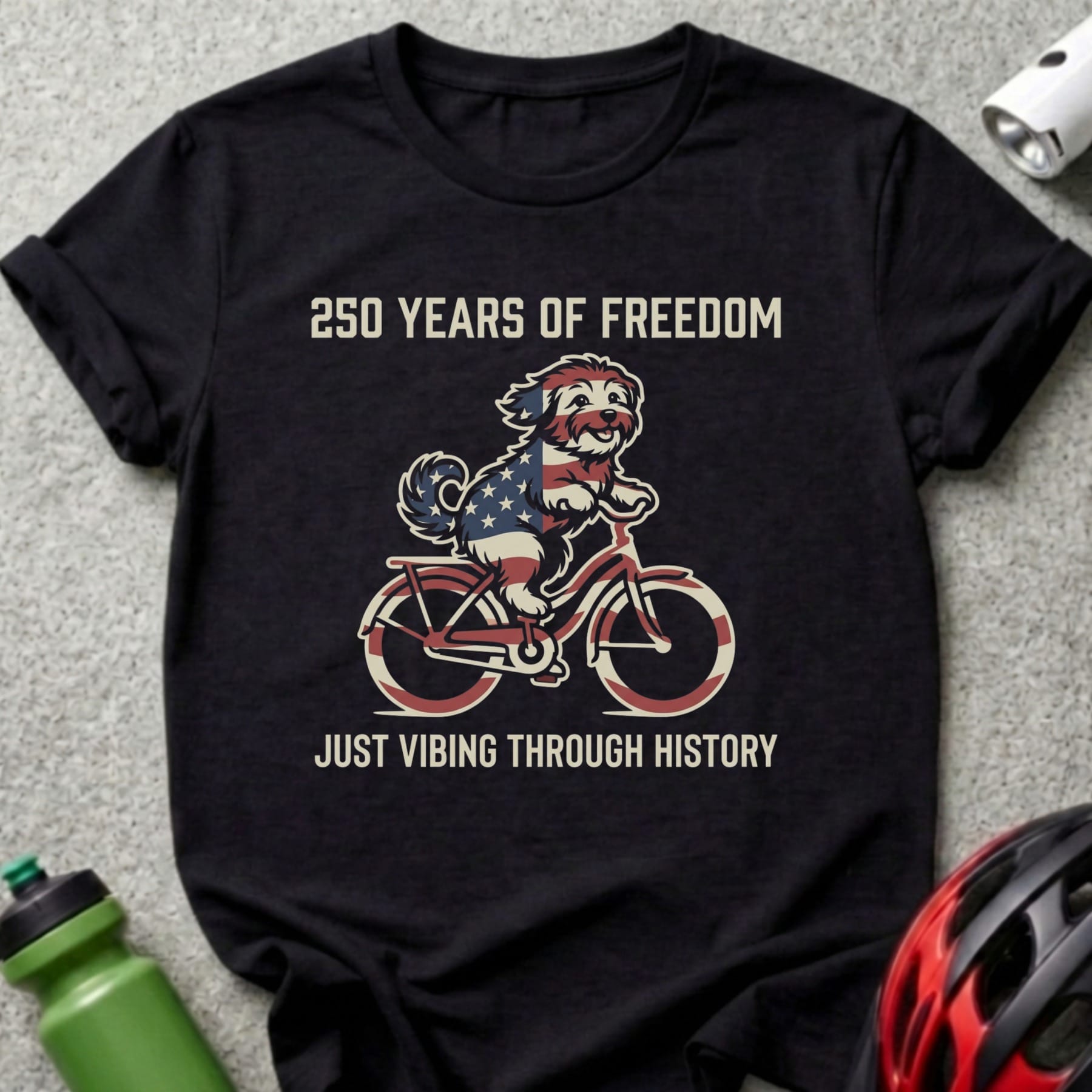 Black t-shirt with patriotic dog riding a bike, "250 Years of Freedom" and "Just Vibing Through History."
