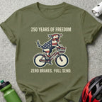 Dog in American flag bandana rides bicycle with text "250 YEARS OF FREEDOM".