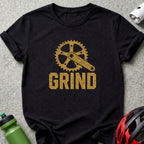 Black t-shirt with gold "GRIND" text and a bicycle crankset graphic.