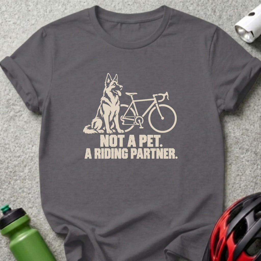 Charcoal t-shirt featuring a cream-colored graphic of a German Shepherd beside a bicycle and text reading, "Not a pet. A riding partner."