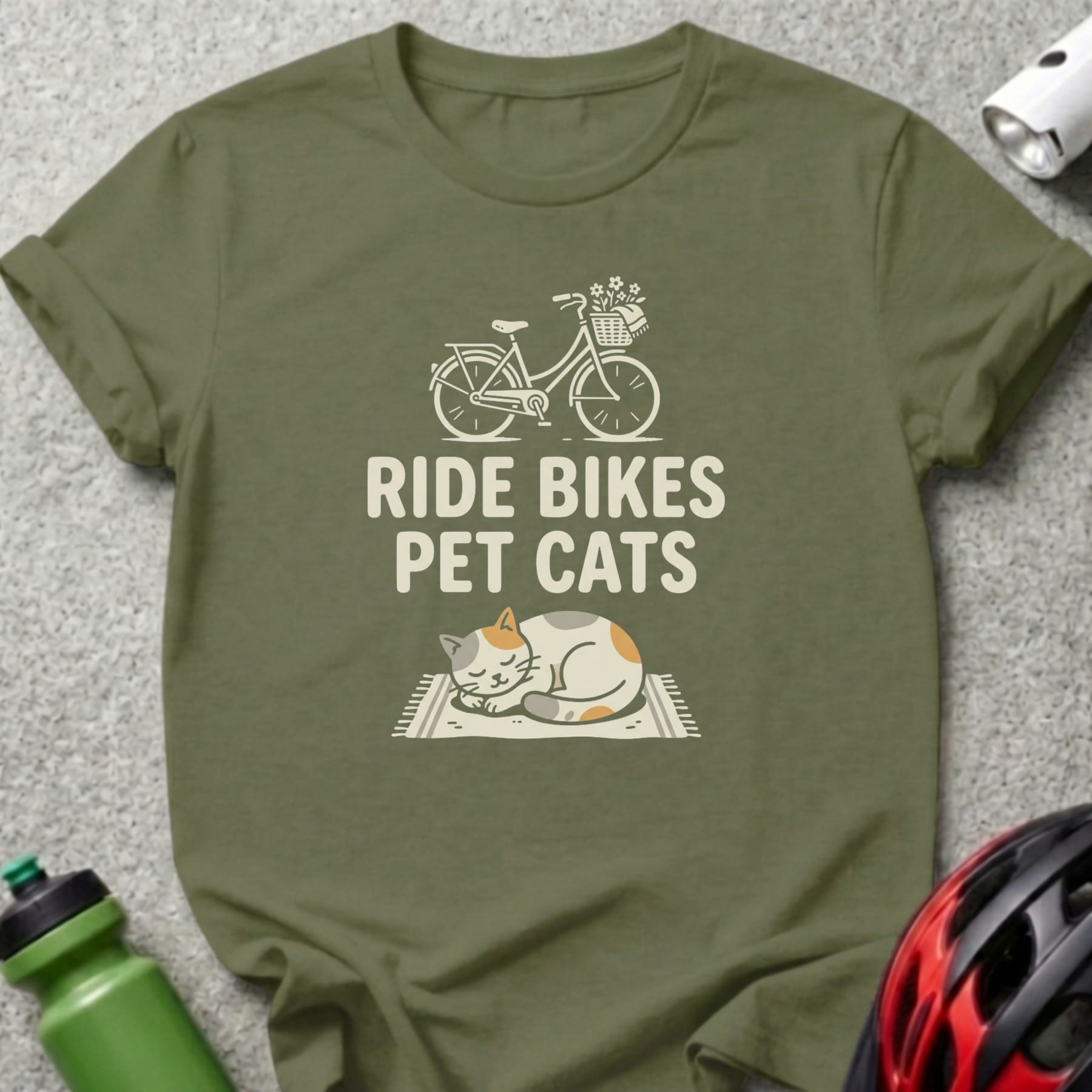 Green t-shirt with "Ride Bikes Pet Cats" text and a sleeping cat with a bicycle illustration.
