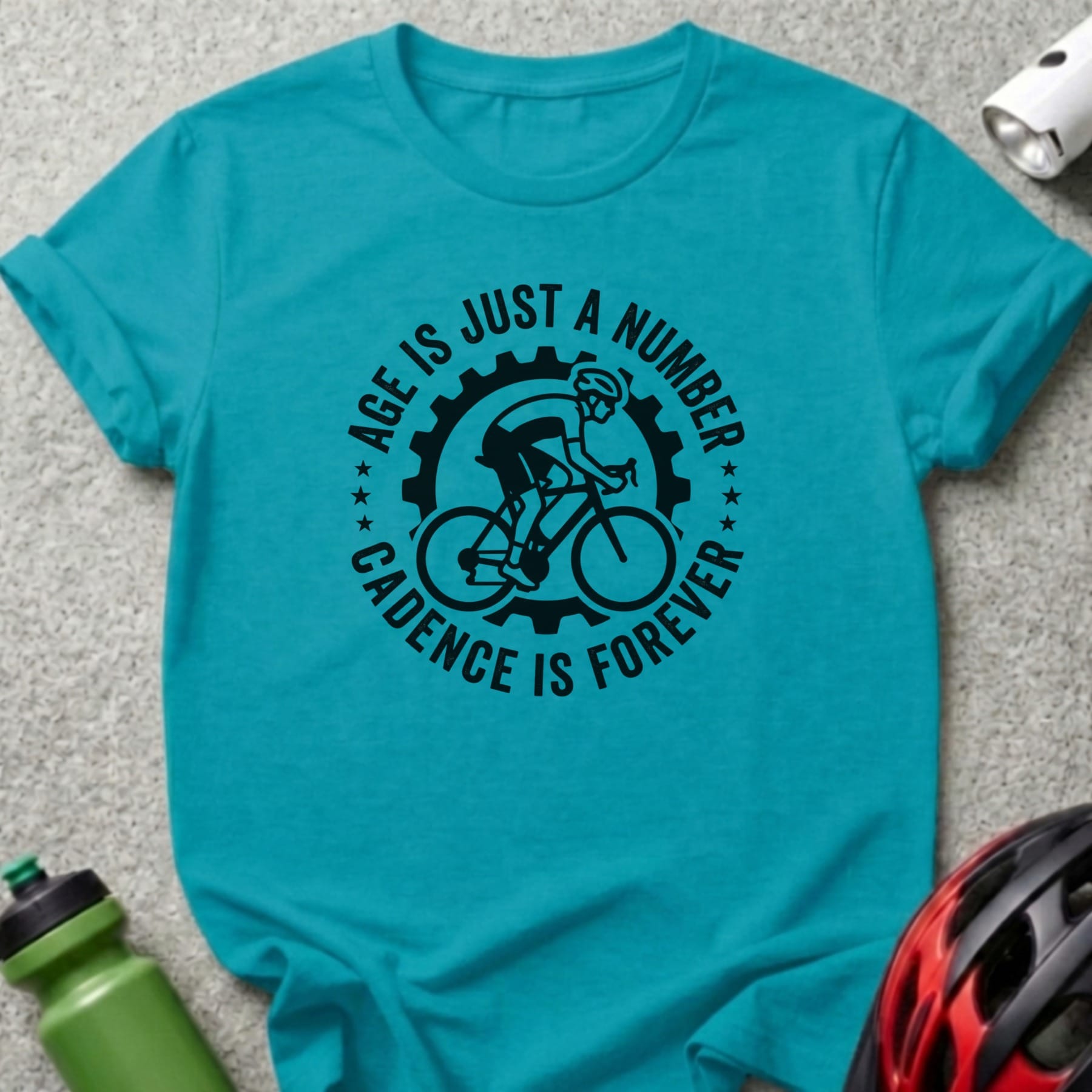 Turquoise t-shirt with black cyclist graphic and text "Age is just a number. Cadence is forever."