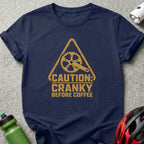 Navy t-shirt with distressed yellow graphic featuring a bike crank and "Caution: Cranky Before Coffee."
