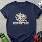 Navy blue t-shirt featuring a cream graphic of a cat sleeping inside a bicycle helmet with the text RECOVERY RIDE.
