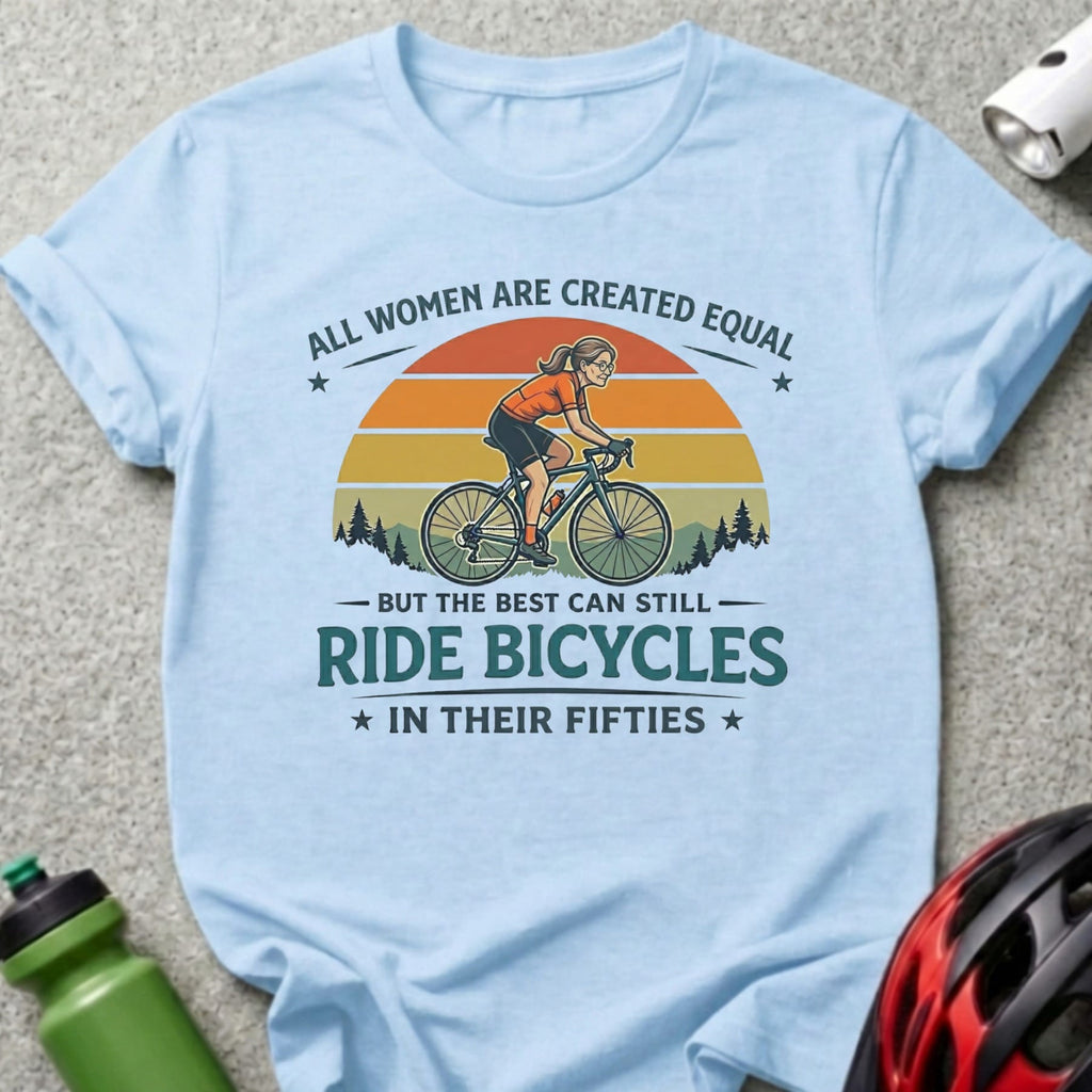 Light blue t-shirt with vintage cyclist graphic and text "All women are created equal but the best can still ride bicycles in their fifties".