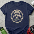 Navy t-shirt with a beige graphic stating "AGE IS A GEAR. USE IT."