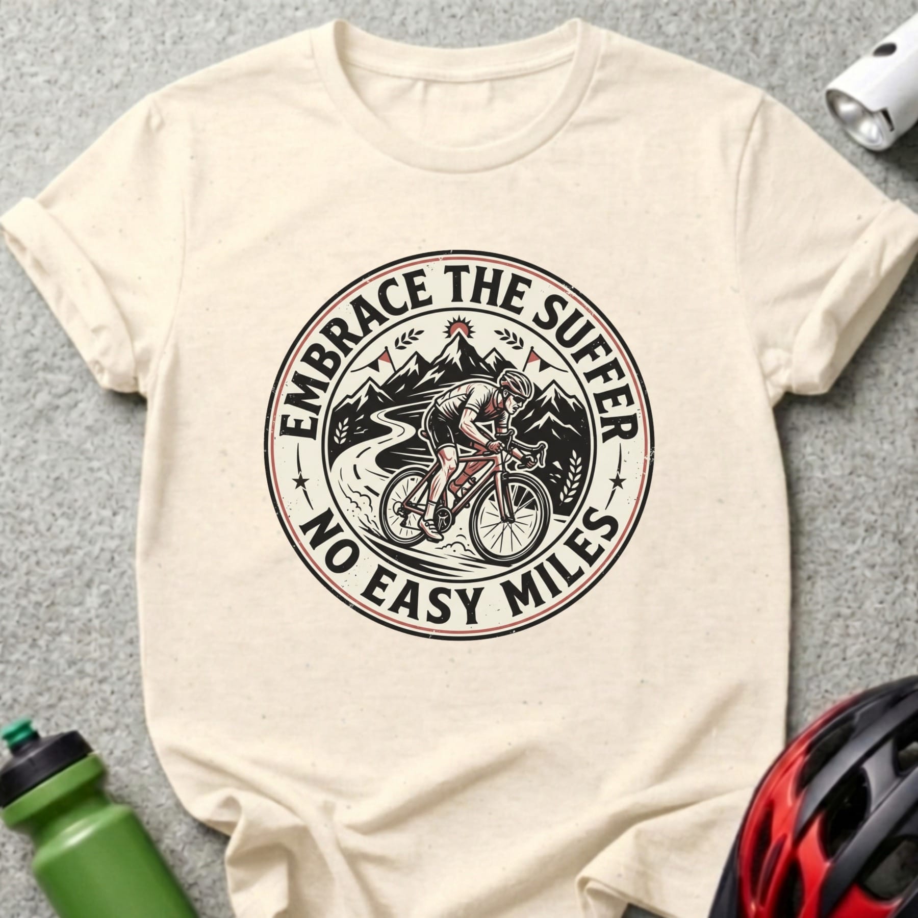 T-shirt graphic with cyclist on mountain road, "Embrace the Suffer No Easy Miles" text.