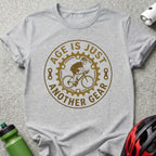 Gray t-shirt with "Age is just another gear" cyclist graphic.
