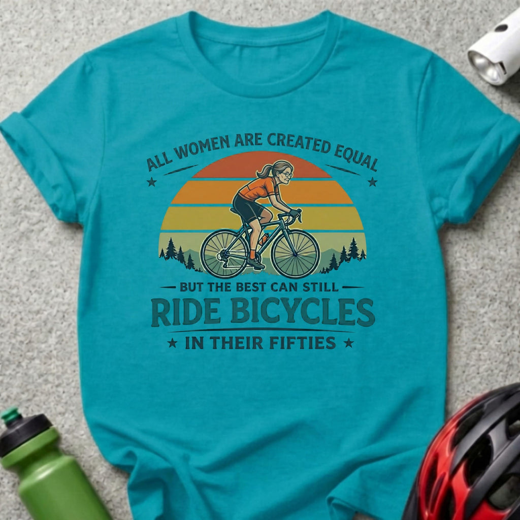 Turquoise t-shirt with graphic of woman biking, text "All women are created equal but the best can still ride bicycles in their fifties."