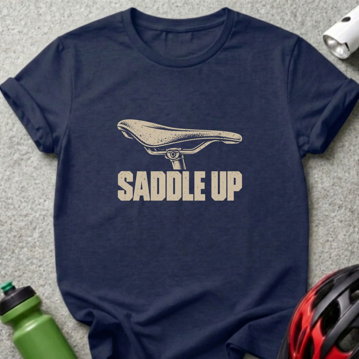 A navy blue t-shirt with a beige graphic of a bicycle saddle and the text SADDLE UP.
