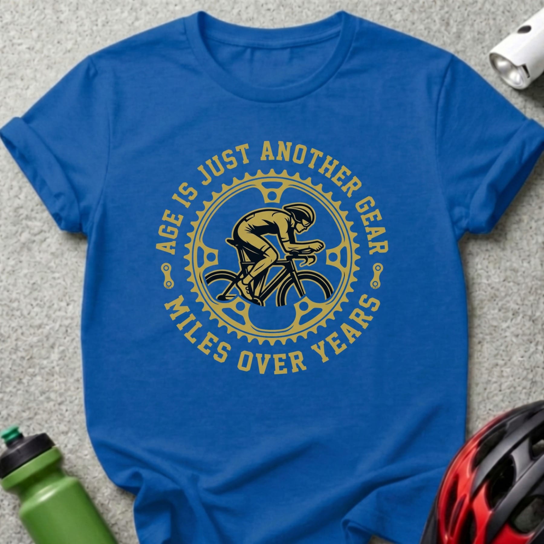 Blue t-shirt with cyclist graphic and text "AGE IS JUST ANOTHER GEAR MILES OVER YEARS".