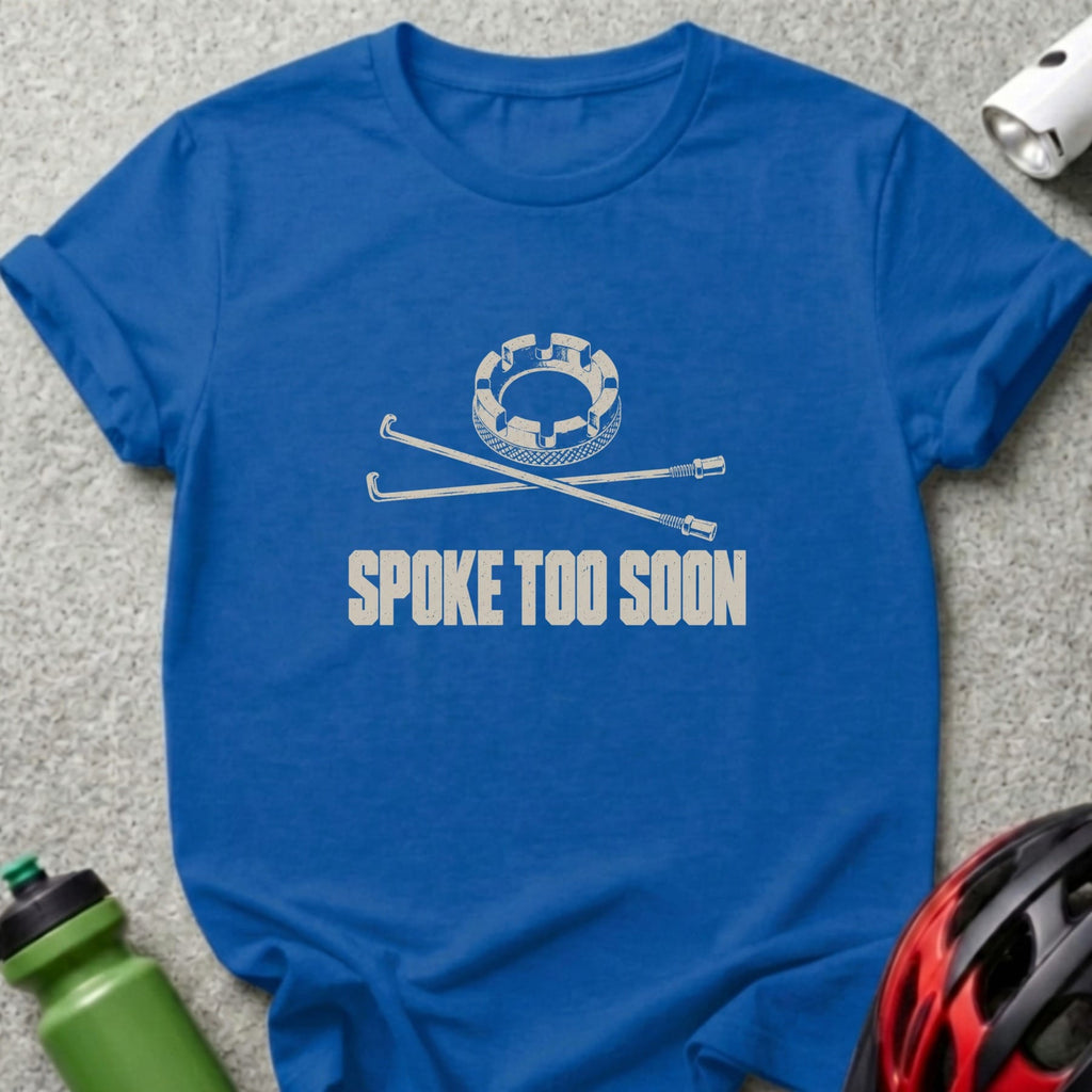 Royal blue t-shirt featuring a white graphic of crossed bicycle spokes and a gear, with the text SPOKE TOO SOON.