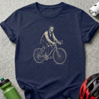 Abraham Lincoln on a bicycle, sketched in navy blue on a dark t-shirt.