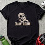 A black t-shirt with a graphic of a bicycle crank wearing a flat cap, accompanied by the text CRANKY OLD MAN.