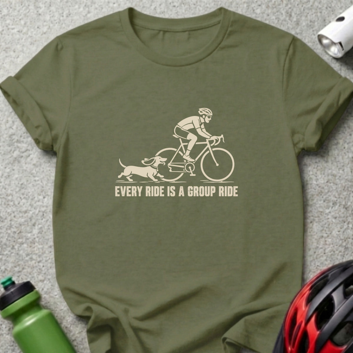 Olive green crewneck t-shirt featuring a graphic of a cyclist and dachshund with text stating EVERY RIDE IS A GROUP RIDE.