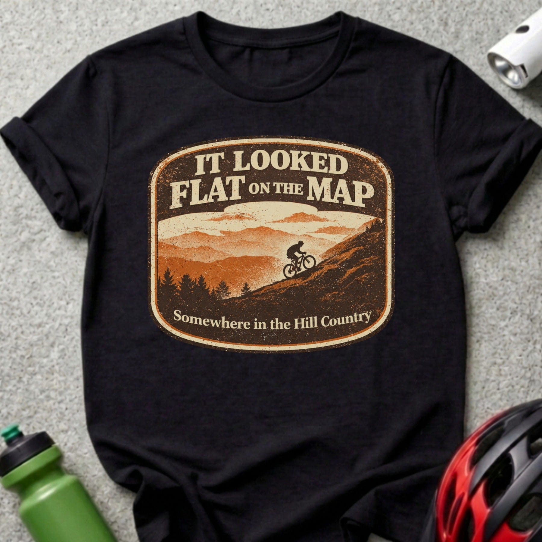T-shirt with "It Looked Flat On The Map Somewhere in the Hill Country" and mountain biker graphic.