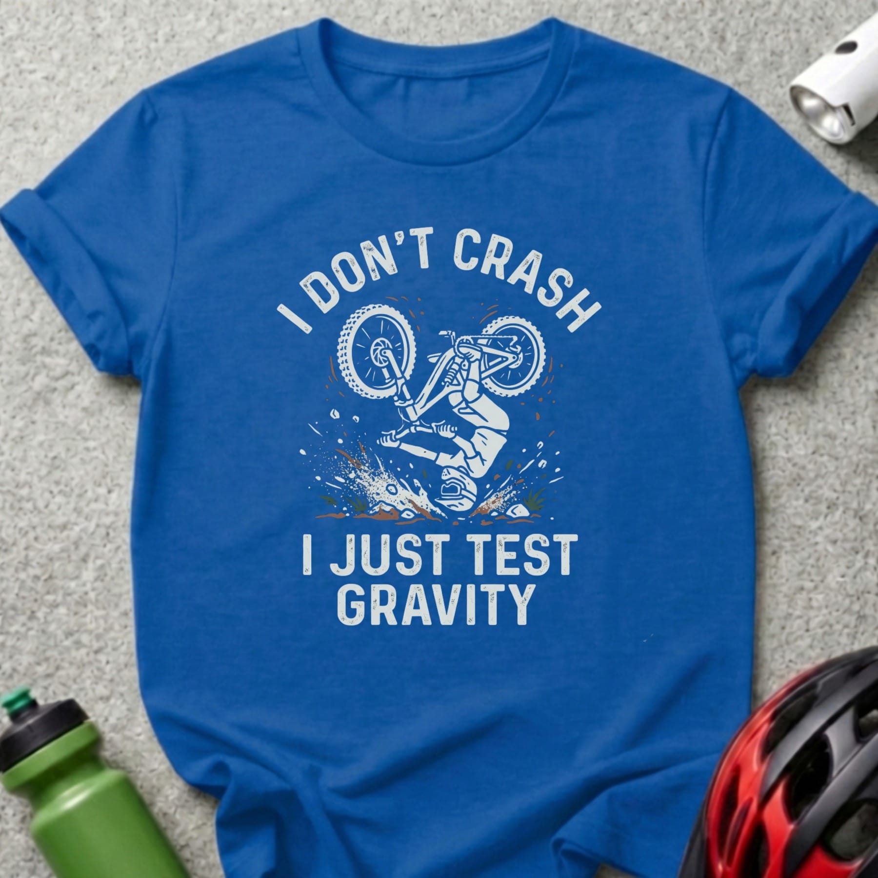 Blue t-shirt with "I Don't Crash I Just Test Gravity" and biker graphic.