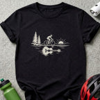Black short-sleeve t-shirt featuring a white graphic of a cyclist, trees, sun, and an acoustic guitar reflection.