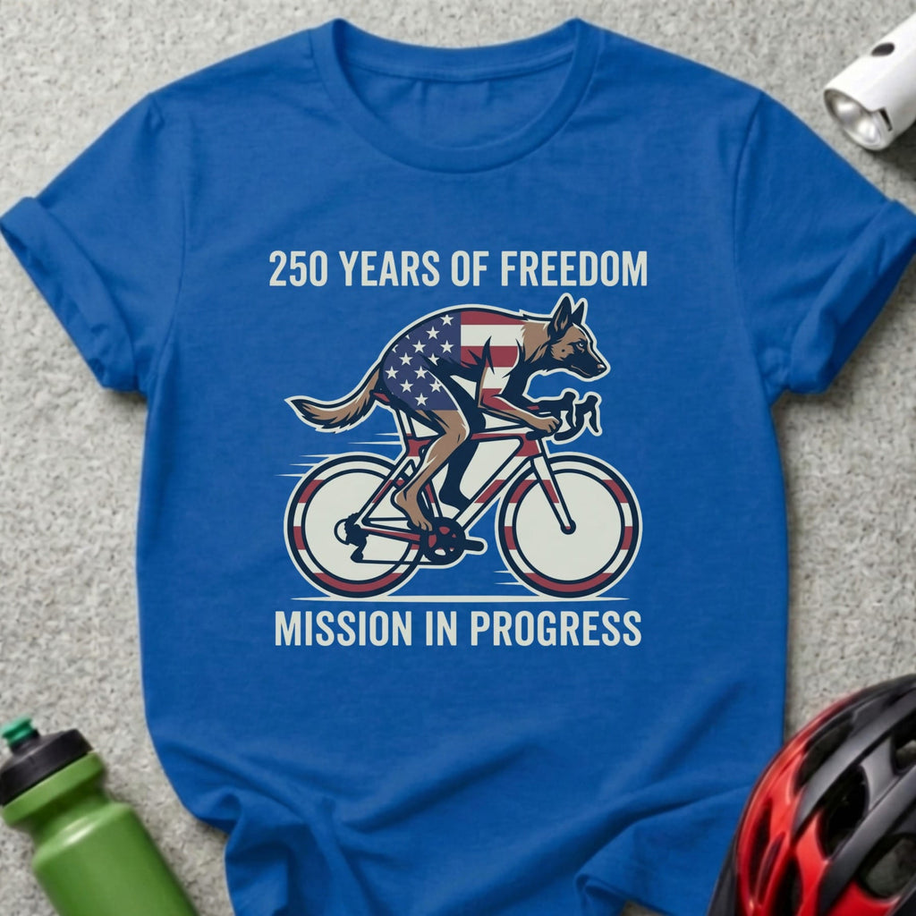 Blue t-shirt with a German Shepherd cyclist on a bike, USA flag details, and text "250 YEARS OF FREEDOM MISSION IN PROGRESS".