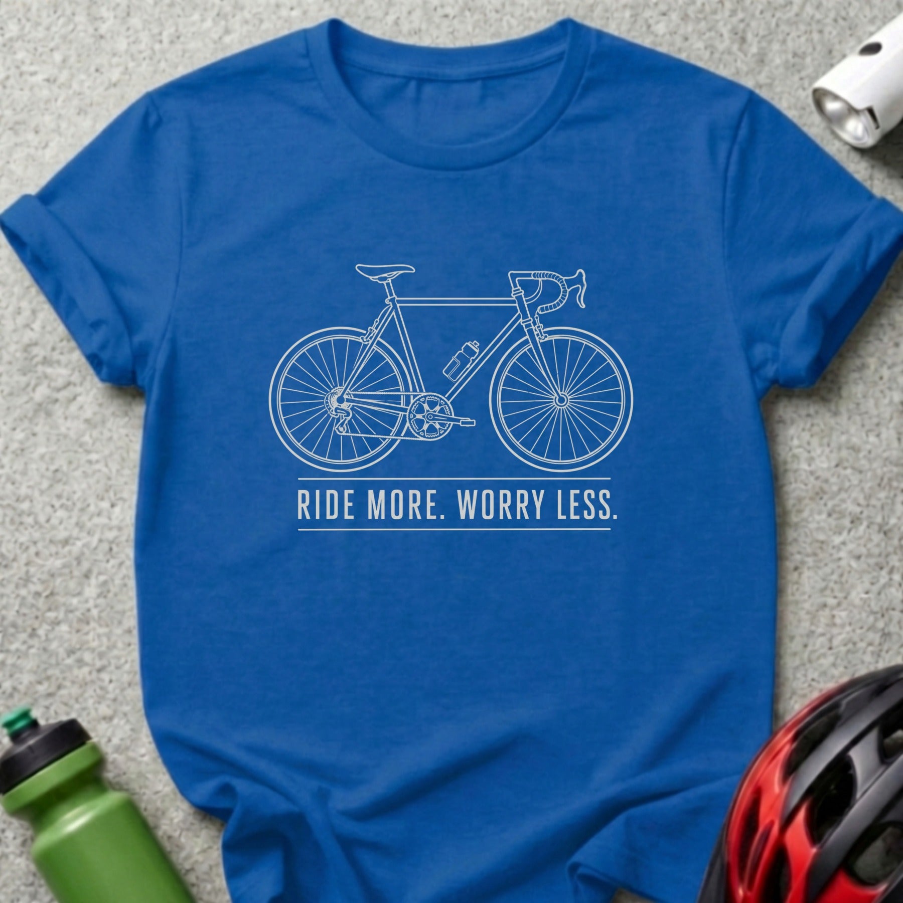 Blue t-shirt with white outline of a bicycle and text "RIDE MORE. WORRY LESS."
