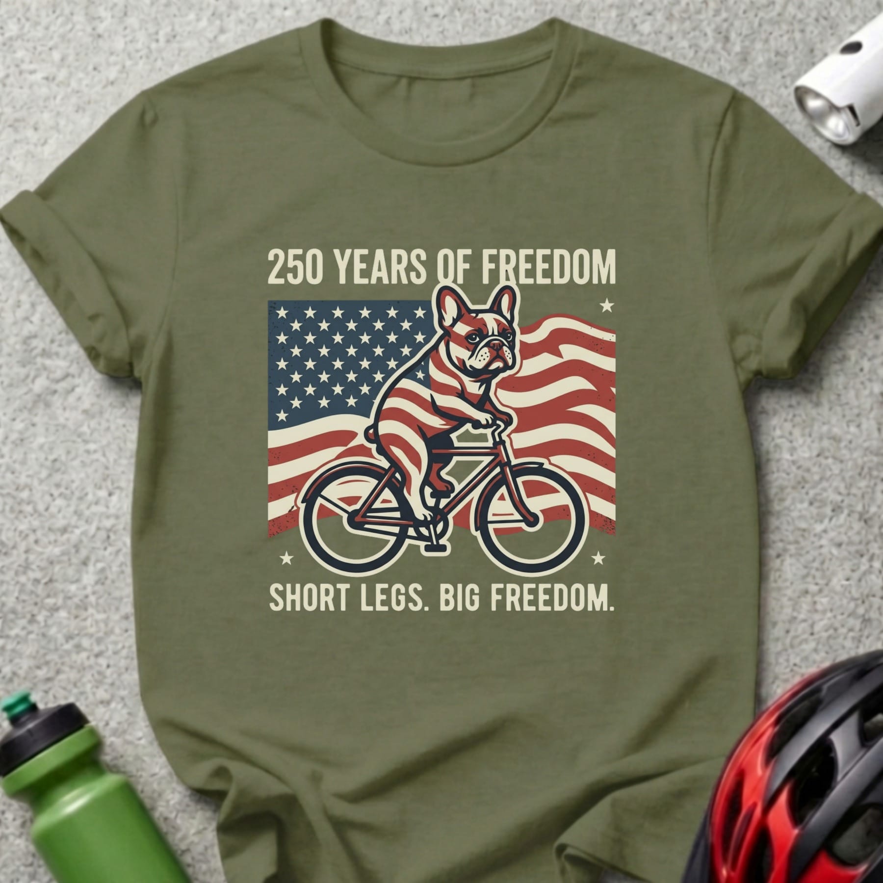 French bulldog on bicycle with American flag and text: "250 Years of Freedom. Short Legs. Big Freedom."