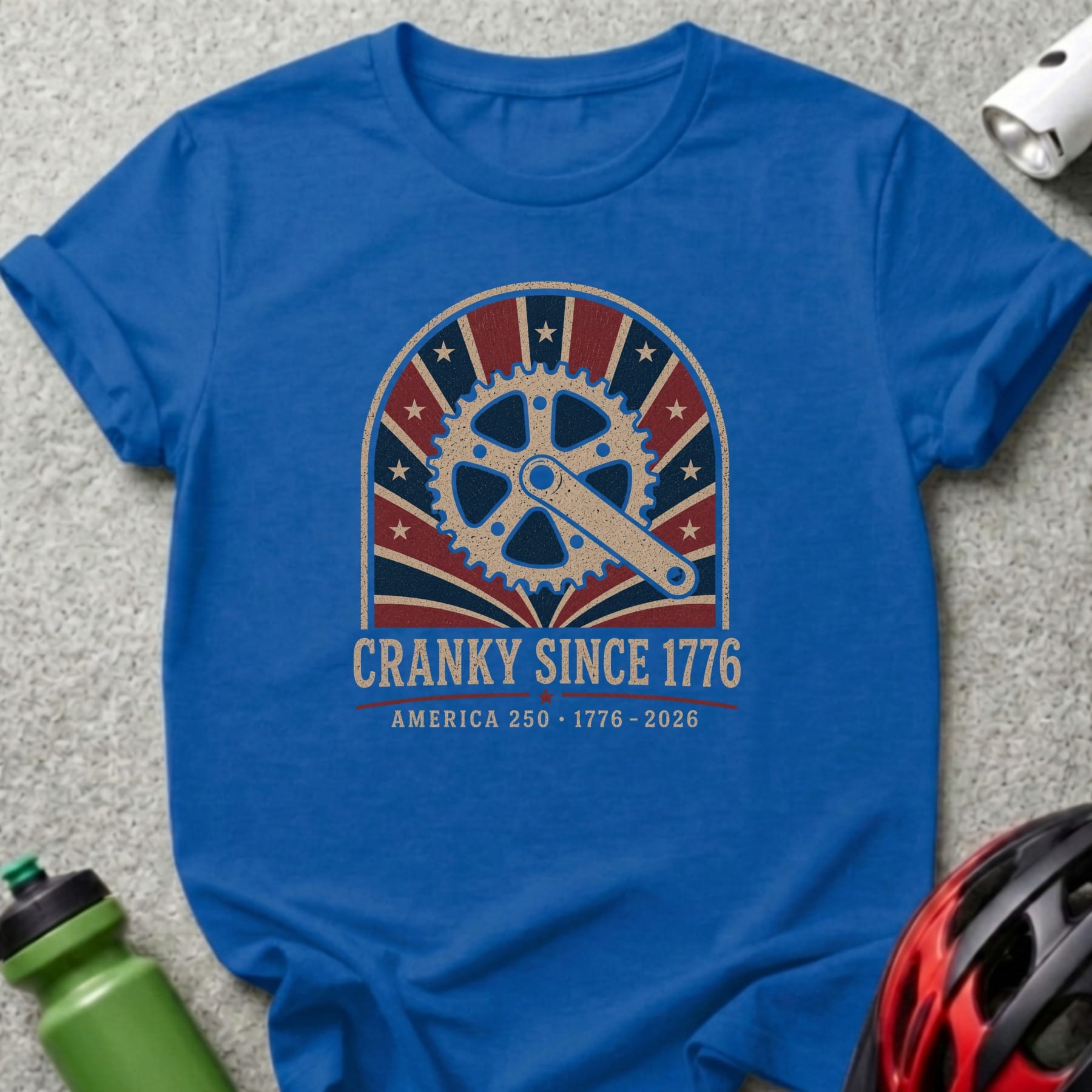 Blue t-shirt with "Cranky Since 1776 America 250" text and bicycle crank graphic.