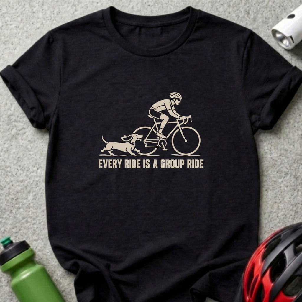 A black short-sleeved t-shirt featuring a beige graphic of a cyclist and dachshund with text stating EVERY RIDE IS A GROUP RIDE.