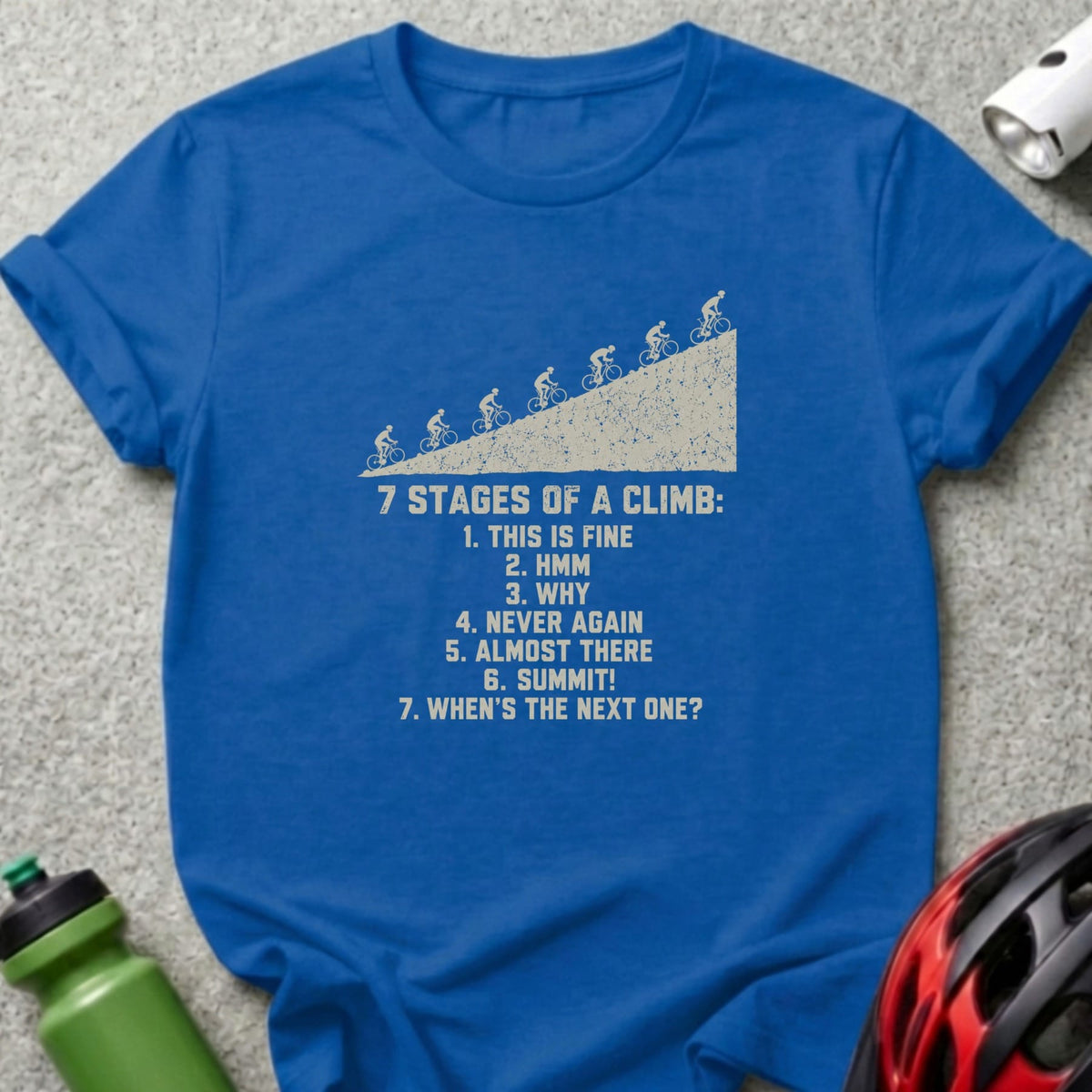 Blue crewneck t-shirt with graphic showing seven stages of a cycling climb and numbered text.