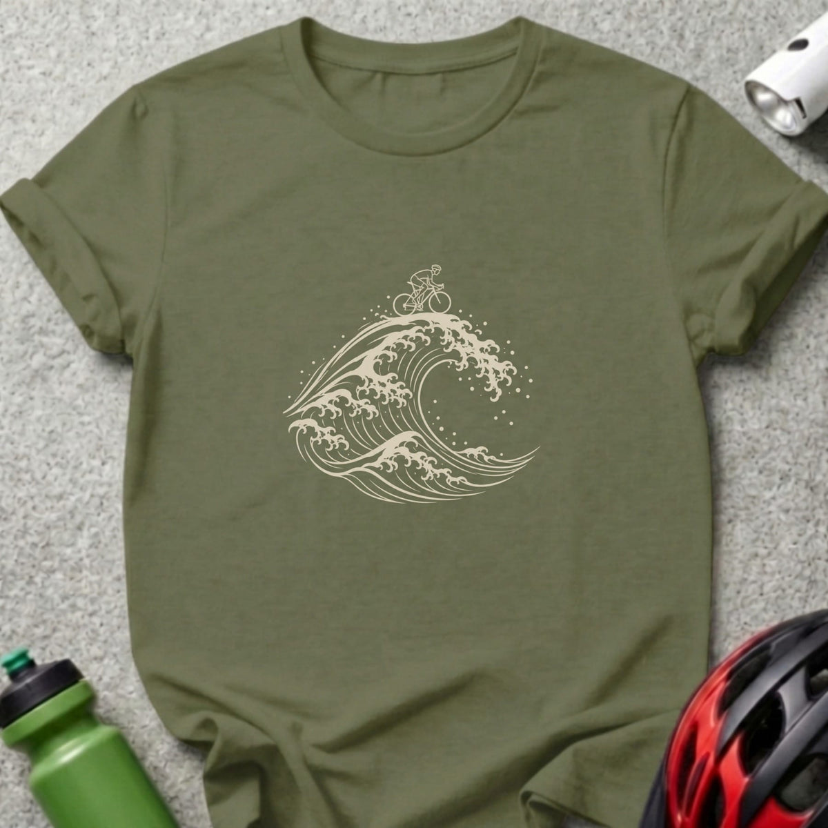 An olive green t-shirt featuring a beige line drawing of a cyclist riding atop a large wave.