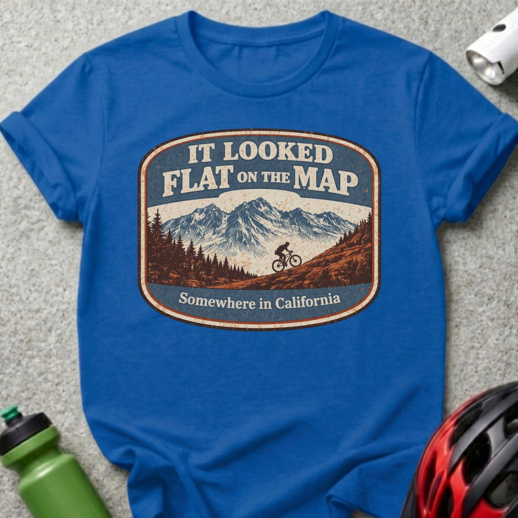 Blue t-shirt with "IT LOOKED FLAT ON THE MAP" graphic and mountain biker.